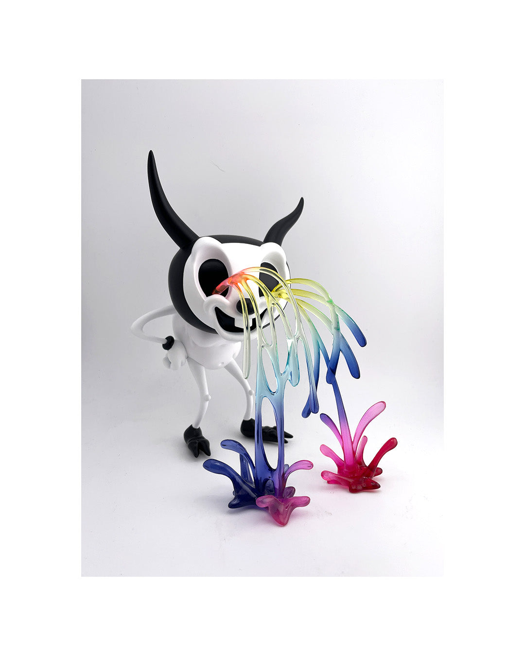 Colorful glass sculpture of a creature with horns on a white background