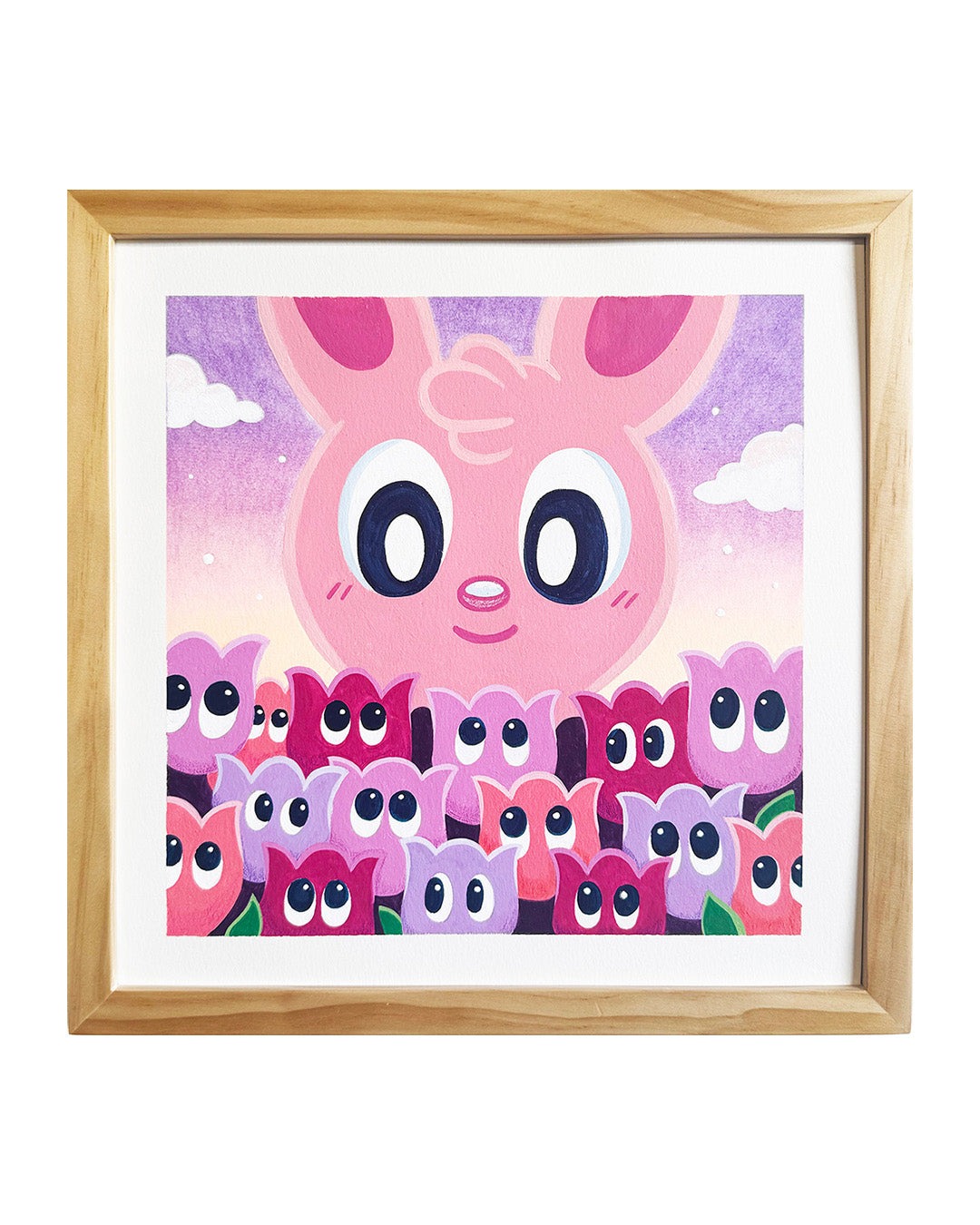 Framed artwork of a pink bunny looking down at a bed of tulips with eyes on them