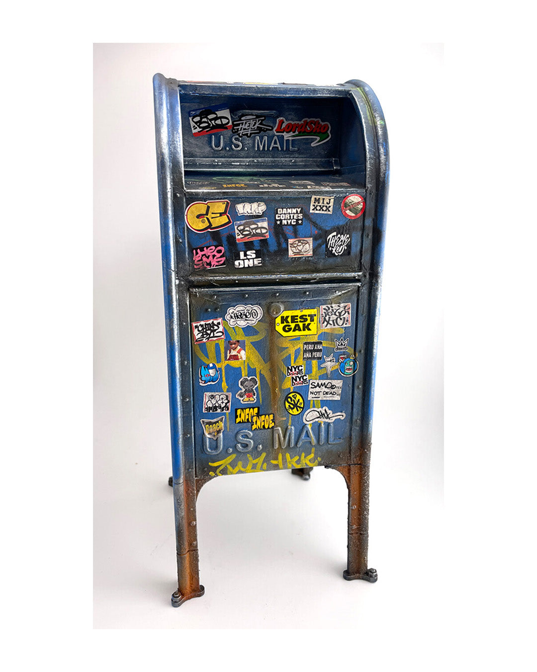 Vintage U.S. Mail box with numerous stickers on a white background